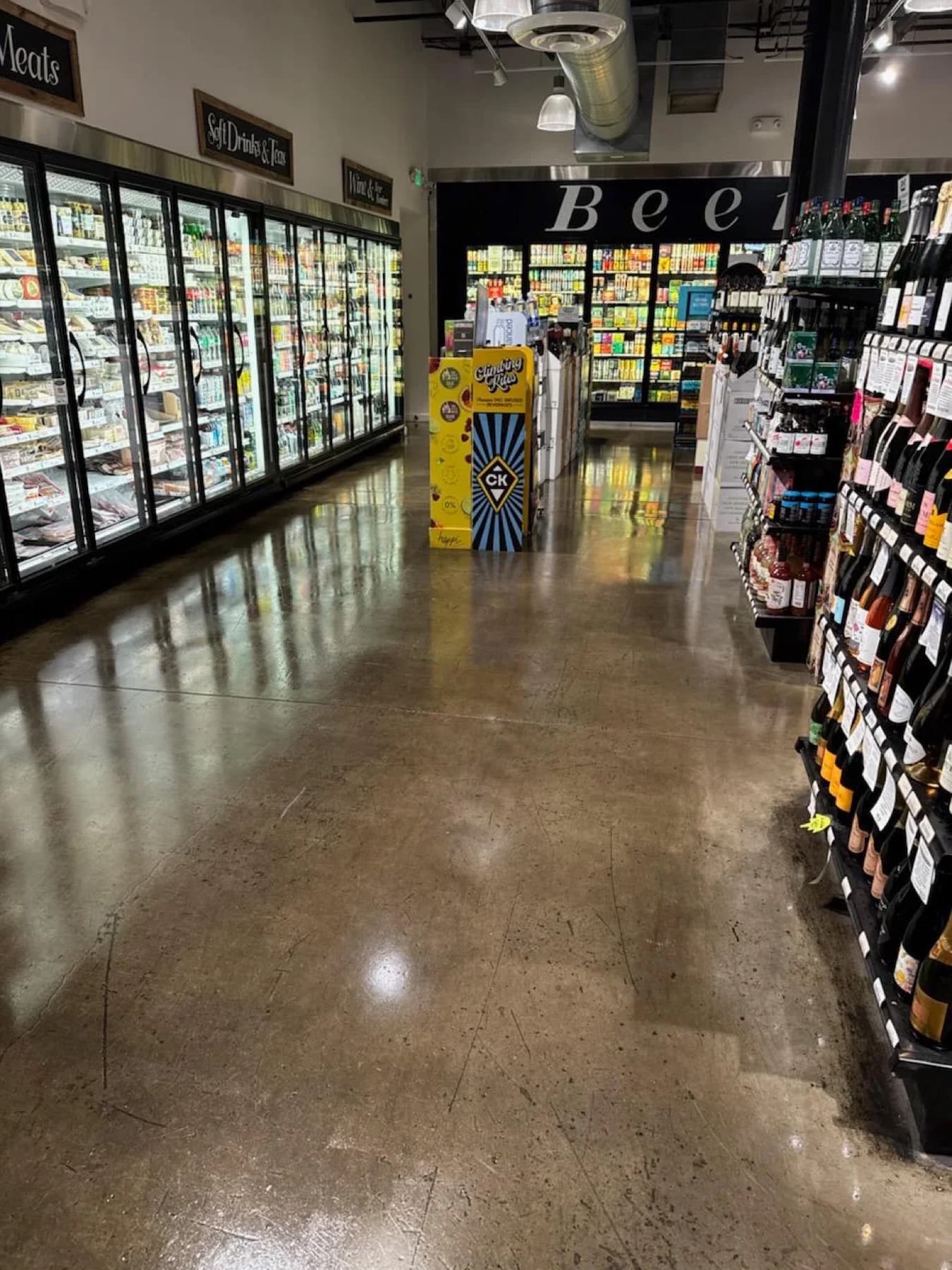 Grocery aisle with polished concrete flooring reflecting the ceiling lights after a scrub and polish