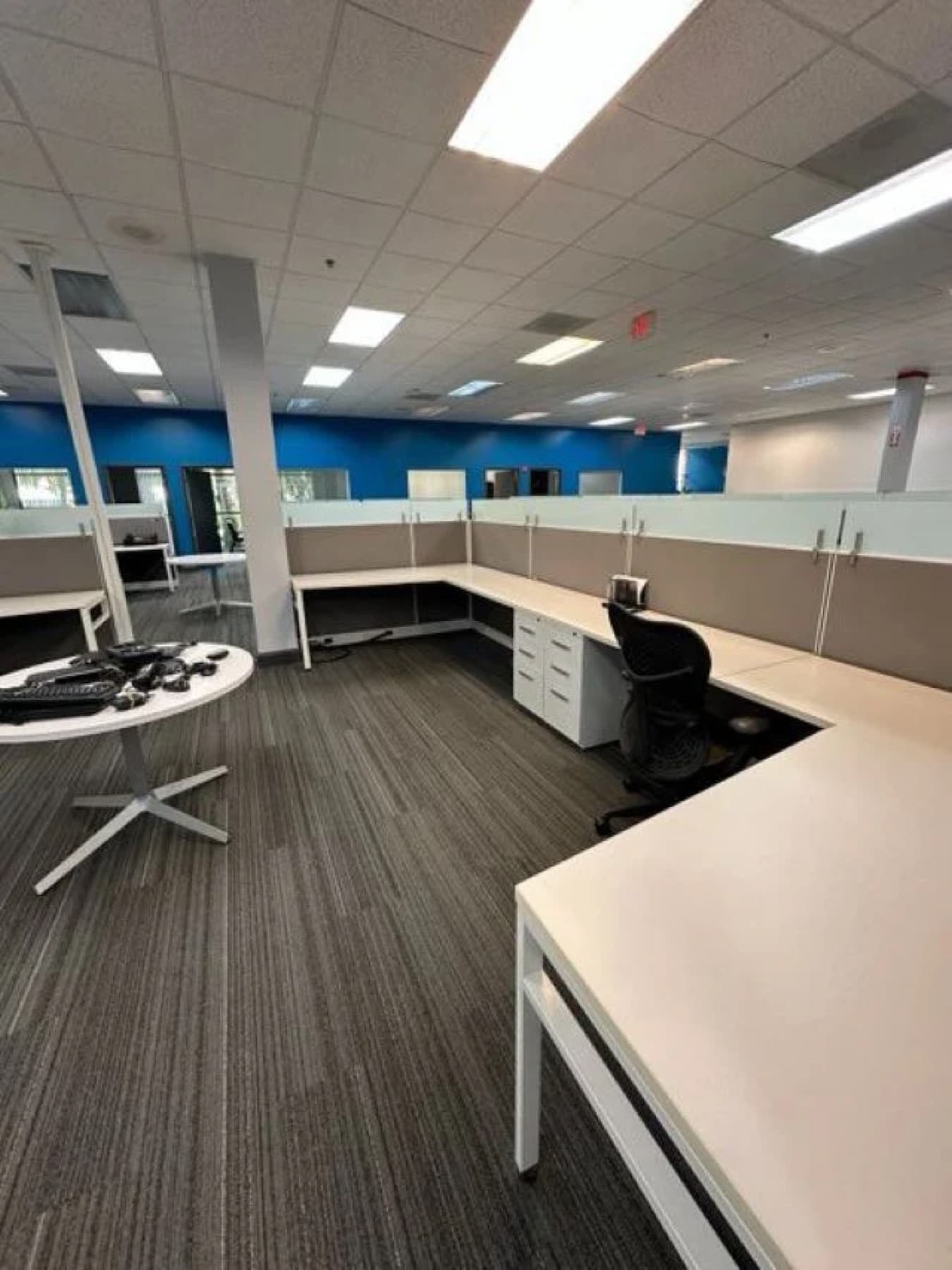 Open-plan office workstations with vacuumed carpet after a nightly cleaning visit